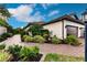 Landscaped walkway leads to a charming house with a brown door and two-car garage at 6226 Plateau Ct, Bradenton, FL 34203