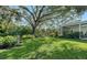 Landscaped backyard with lush greenery and large tree at 653 40Th St, Sarasota, FL 34234