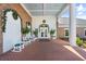 Covered entryway to the clubhouse with brick pavers, white rocking chairs, and holiday decorations at 6640 Pineview Ter # 6640, Bradenton, FL 34203
