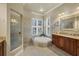 Spa-like bathroom with soaking tub, walk-in shower, and granite vanity at 7041 Beechmont Ter, Lakewood Ranch, FL 34202