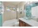 Small bathroom with a bathtub, glass sink, and teal walls at 7041 Beechmont Ter, Lakewood Ranch, FL 34202