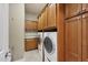 Laundry room with washer, dryer, and wood cabinets at 7041 Beechmont Ter, Lakewood Ranch, FL 34202