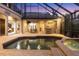 Evening view of the pool, spa, and outdoor kitchen at 7041 Beechmont Ter, Lakewood Ranch, FL 34202