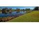 Lakefront backyard with lush grass and water views at 7156 Rue De Palisades # 3, Sarasota, FL 34238