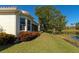 Peaceful backyard with lake view, lush landscaping, and house exterior at 7156 Rue De Palisades # 3, Sarasota, FL 34238