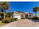 Single-story home features a white exterior, tile roof, and landscaped yard at 7156 Rue De Palisades # 3, Sarasota, FL 34238
