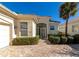 Front view of charming house with white walls, paver driveway, and manicured landscaping at 7156 Rue De Palisades # 3, Sarasota, FL 34238