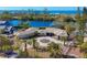 Tropical waterfront home with circular driveway, lush landscaping, and ocean views at 7618 Midnight Pass Rd, Sarasota, FL 34242