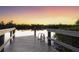 Wooden dock with boat lift at sunset at 7618 Midnight Pass Rd, Sarasota, FL 34242