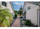 A peaceful backyard featuring a brick paver walkway and lush landscaping at 7806 Ontario Street Cir # 7806, Sarasota, FL 34243