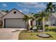 Charming home showcasing a two-car garage, manicured lawn, and tropical landscaping with vibrant palm trees at 7806 Ontario Street Cir # 7806, Sarasota, FL 34243