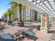 Relaxing pool deck with lounge chairs and pergola at 800 N Tamiami Trl # 201, Sarasota, FL 34236