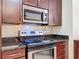 Stainless steel appliances and dark wood cabinetry in kitchen at 850 S Tamiami Trl # 402, Sarasota, FL 34236