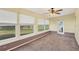 Sunroom with windows overlooking backyard, ceiling fan, and carpeted floor at 865 Beverly Rd, Venice, FL 34293