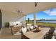 Covered back porch with outdoor dining and seating area overlooking water at 10124 Silent Night Ln, Sarasota, FL 34241