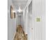 Long hallway with light walls and wood-look flooring leads to bedrooms and other rooms at 1111 49Th Avenue W Dr, Bradenton, FL 34207