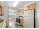 Bright kitchen features wood cabinets, appliances, and a view into the dining area at 1111 49Th Avenue W Dr, Bradenton, FL 34207