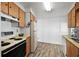 Kitchen with wood cabinets, laminate floor, and white appliances at 1111 49Th Avenue W Dr, Bradenton, FL 34207