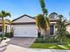 Single-story home with white garage door, landscaping, and brick pavers at 153 Soliera St, Nokomis, FL 34275