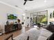 Gathering room features sliding glass doors to a screened patio, hardwood floors and comfortable seating at 153 Soliera St, Nokomis, FL 34275