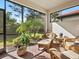 Relaxing screened porch with wicker furniture and view of backyard at 153 Soliera St, Nokomis, FL 34275