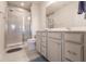 Modern bathroom featuring a walk-in shower, dual vanities, and tiled floor at 16351 Coconut Palm Dr, Port Charlotte, FL 33953