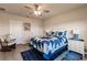 Inviting bedroom with blue bedding, ceiling fan, and rocking chair at 16351 Coconut Palm Dr, Port Charlotte, FL 33953