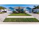 Light blue home with attached two-car garage, landscaped yard, and paved driveway at 16351 Coconut Palm Dr, Port Charlotte, FL 33953