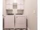 Convenient laundry room with washer, dryer, and upper cabinets for storage at 16351 Coconut Palm Dr, Port Charlotte, FL 33953