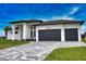 Modern home with a paved driveway and two-car garage at 230 W Pine Valley Ln, Rotonda West, FL 33947