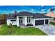 Modern two-story house with a dark roof and light-colored walls, a two-car garage and well-maintained lawn at 230 W Pine Valley Ln, Rotonda West, FL 33947