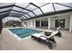 Enclosed pool and lanai with lounge chairs and canal view at 230 W Pine Valley Ln, Rotonda West, FL 33947