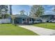 Charming light blue house with a spacious driveway and lush green yard at 335 49Th W St, Palmetto, FL 34221