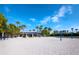 Beach volleyball court with covered seating and nearby palm trees at 3455 Winding Oaks Dr # 28, Longboat Key, FL 34228