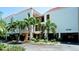 Condo building exterior showcasing a modern design with palm trees at 3705 E Bay Dr # 212, Holmes Beach, FL 34217