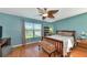 Bright bedroom with wood flooring, ceiling fan, and backyard view at 3920 Douglas Hill Pl, Parrish, FL 34219