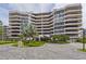 Modern high-rise condominium building with lush landscaping and paver driveway at 545 Sanctuary Dr # B406, Longboat Key, FL 34228