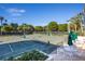 Tennis courts with seating area and lush landscaping at 545 Sanctuary Dr # B406, Longboat Key, FL 34228