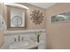 Powder room with modern vanity, decorative mirror, and neutral color scheme at 575 Sutton Pl # T-4, Longboat Key, FL 34228