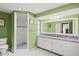 Green bathroom with granite vanity and walk-in shower at 584 Beverly Rd, Venice, FL 34293