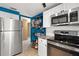 Updated kitchen with stainless steel appliances and blue accent wall at 584 Beverly Rd, Venice, FL 34293