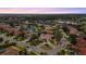 A stunning aerial view of a home showcases the property's lush landscaping, mature trees and serene lakeside setting at 7042 Twin Hills Ter, Lakewood Ranch, FL 34202