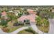 A picturesque aerial view of a home boasts a circular driveway, lush landscaping, and a well-manicured lawn at 7042 Twin Hills Ter, Lakewood Ranch, FL 34202