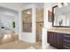 Bathroom featuring a glass shower, tile surround, vanity with granite countertop, and neutral paint at 7042 Twin Hills Ter, Lakewood Ranch, FL 34202