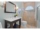 Bathroom featuring a glass shower, tile surround, and vanity with elegant mirror and fixtures at 7042 Twin Hills Ter, Lakewood Ranch, FL 34202