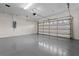 Spacious garage with epoxy floors, storage shelves, and an insulated door at 7042 Twin Hills Ter, Lakewood Ranch, FL 34202