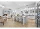 Bright open kitchen features a large center island with seating, white cabinetry, and granite countertops at 7042 Twin Hills Ter, Lakewood Ranch, FL 34202