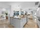 Spacious kitchen island featuring white cabinets, prep sink, and backyard views at 7042 Twin Hills Ter, Lakewood Ranch, FL 34202