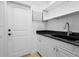 Well-lit laundry room with granite countertops, white cabinets, sink, and drying rack at 7042 Twin Hills Ter, Lakewood Ranch, FL 34202