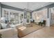 Stunning living room with elegant decor, a large map, and French doors to a separate office area at 7042 Twin Hills Ter, Lakewood Ranch, FL 34202